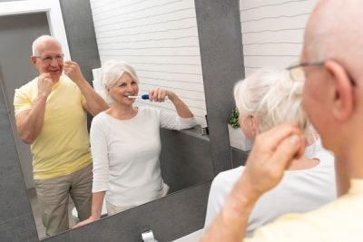 Old senior people cleaning teeth in the bathroom